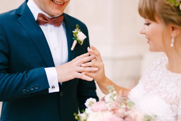 The Bride Puts A Ring On The Grooms Finger And Holds A Bouquet In Her Picture Id1315852120